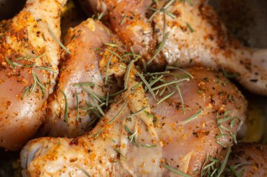 Çiğ tavuk budu ve baharat. Baharatlı tavuk, biberiye ve kırmızı biber. Pişmemiş et. Kasede çiğ et. Ev yapımı barbekü. Et ve bitkiler..