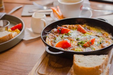 Tavada domates ve jambonlu sahanda yumurta. Kahvaltı masası servisi. Domates ve ekmekle omlet. İspanyol tortilla 'sı. Pesto ve sebzeli yumurta. Yemek yemeye hazır. Sağlıklı yemek.. 