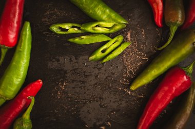 Siyah panoda kırmızı kırmızı kırmızı biber ve fotokopi alanı. Kırmızı ve yeşil biber yığını. Parlak doğal altyapı. Kırmızı biber kes. Renkli baharatlı biber. Organik sebzeler. Baharatlı Meksika yemeği. Markette alışveriş.. 