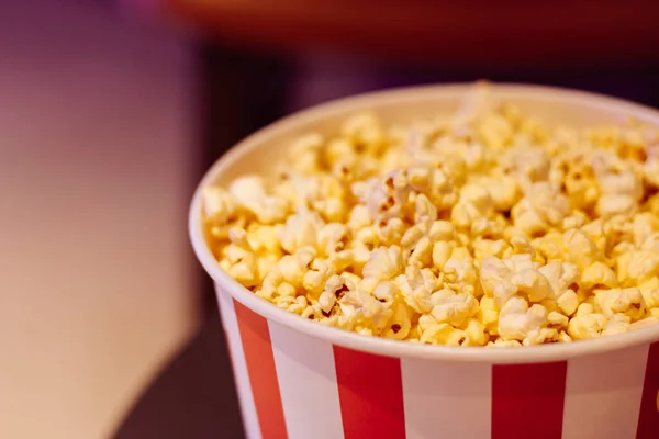 Popcorn box, close up. Movie theatre popcorn background. Entertainment concept. Cinema trendy. Movie snack. Salted popcorn in bucket. Fast food.
