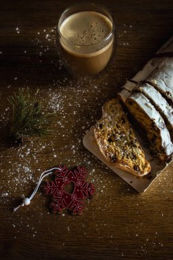 Kahve fincanı ve dekorasyon oyuncaklarıyla süslenmiş bir Noel. Kakao ve pudra şekerli Noel ekmeği. Yeni yıl dekorasyonu. Şenlik masasında kuru üzümlü ev yapımı stollen. Kış kahvaltısı. 