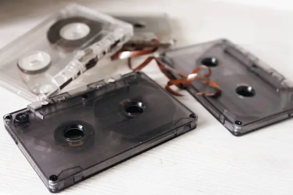 Old audio tape on white background. Retro audio format. Cassette tapes. 90\'s nostalgia concept. Old fashioned lifestyle. Archival objects. Analogue record equipment. Vintage music storage. Aged audio technology.