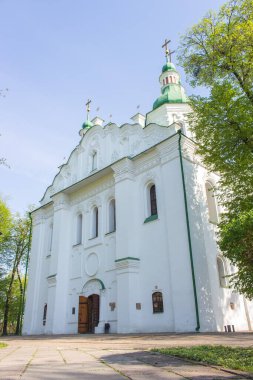 Kyiv, Ukrayna - 04 11 2024: Kyiv 'deki St. Cyril kilisesinin dışı. Cyril Kilisesi 'nin arka bahçesinde bahar mevsimi. Ukrayna kültürünün dini mirası. Ortodoks Hıristiyan manastırı. Haçlı beyaz kilise. Dini mimari.