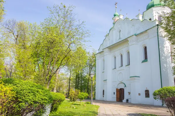 Kyiv, Ukrayna - 04 11 2024: Kyiv 'deki St. Cyril kilisesinin dışı. Cyril Kilisesi 'nin arka bahçesinde bahar mevsimi. Ukrayna kültürünün dini mirası. Ortodoks Hıristiyan manastırı. Haçlı beyaz kilise. Dini mimari.