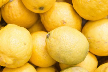 Limonlar satışta. Sulu limon arka planı. Sarı meyveler. Olgun limon yığını. Sarı arkaplan. Citrus hasadı. Sağlıklı beslenme. Vitaminler ve antioksidan.. 