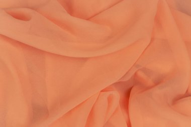 Şeftali rengi arkaplan. Kayısı rengi deseni. Şifon kumaş. Saten arkaplanı katla. İpek kumaş arka plan. Turuncu tekstil. Zarif bir dekorasyon. Kopya alanı ile giysi dokusu. 