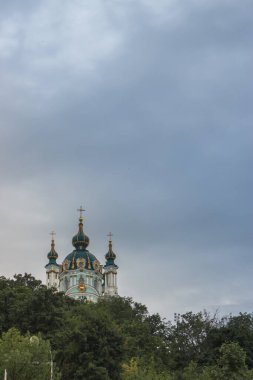 Kyiv 'deki Aziz Andrew Kilisesi. Kyiv 'in ünlü simgesi. Dini mimari. Bulutlu bir günde ortodoks katedrali. St. Andrew Katedrali 'nin arka planında haç var..
