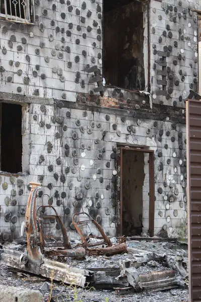 stock image Burnt house and car on backyard. Destroyed building after russian invasion, Ukraine. War in Ukraine. Abandoned damaged home and burnt auto. War disaster. Decayed house after military attack. 