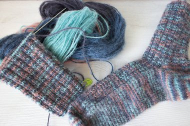 Örgü çorap ve örgü iğneleriyle renkli iplik topu. Güzel örgü desenli alpaka ve yün iplikler. Örgü örerek kapatın. Örgü hobisi. Örgü giyme konsepti. İğne işi arkaplanı. 