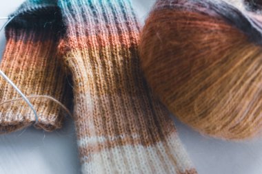 Gökkuşağı renginde örülmüş çoraplar. Örgü moda. Ilık yün çoraplar ve örgü iğneleri. Kıyafetlerin renkleri farklı. Örgü hobileri. El yapımı ürünler. El yapımı örgü giysiler. Parlak örülmüş çoraplar ve iplik yumağı. 