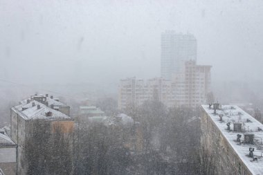 Şehirde kar yağışı. Çatıya kar yağıyor. Kış Kyiv dönüm noktası. Soğuk kış havası. Şehir merkezinde kar yağışı. Kar ve rüzgar. Binalar ve caddeler karla kaplı. Noel havası.