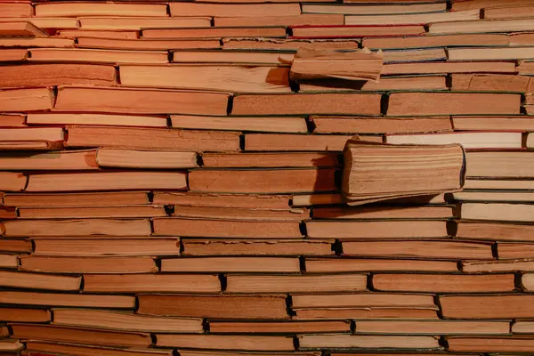 Antik kitaplığın arka planında sıcak ışık var. Bir yığın eski kitap. Arşiv deposu. Okuma hobisi. Kütüphane kitaplığı. Edebiyat konsepti. Gece vakti kitapçıda. Eski kitapları istifledim. Bilgi ve bilgelik. Eski kitaplar dizisi.