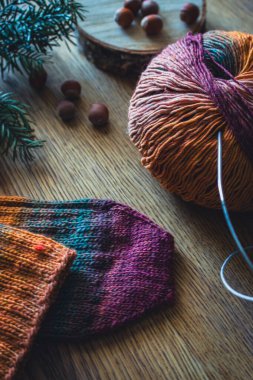 Renkli örgü ipliği, örgü iğneleri ve örgü çorabıyla. Hala hayat örüyorum. Kozalaklı dal, fındık ve iplik yumağı ve örgü iğneleriyle el yapımı çorap. Kışın kalın giysiler. Parlak örgü moda.. 