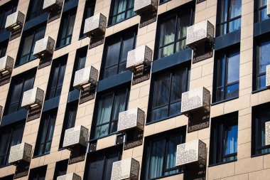 Hava koşulları ve pencereleri olan bir gökdelen. Yüksek binaların dış tarafı. Modern mimari. İş yeri binası. Mimaride geometrik çizgiler. Modern kazıyıcı dış görünüş. Mimaride geometrik çizgiler.