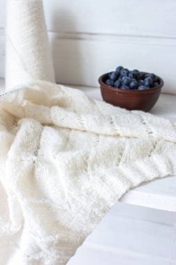 Kil kasesinde taze yaban mersini ve beyaz örgü. Örgü desenli ve pamuklu hırka. Yaz meyveleri ve pamuk örülmüş süveter. Yaz hala hayattır. Organik yiyecekler ve örgü hobisi. 