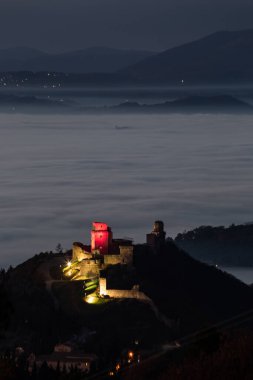 Shore of Trasimeno lake Umbria, Italy with rocks beneath a moody sky.