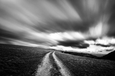 Bir tepenin üstündeki bulutların muhteşem uzun pozlama görüntüsü.