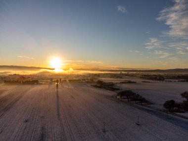 Gün batımında Santa Maria degli Angeli şehrinin hava manzarası, karla kaplı çayırlar..