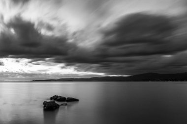 Trasimeno Gölü 'ndeki kayanın uzun pozlu görüntüsü. Umbria, kasvetli gökyüzü..