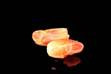 Sıcak renkli bir avuç dolusu hurma doğal bir yüzeye nazikçe uzanır. Derin parıltılarını ve buruşuk dokularını ortaya çıkarır. Parlak ciltleri, doğal şeker bakımından zengin, karşı konulmaz bir tatlılığı çağrıştırıyor.. 