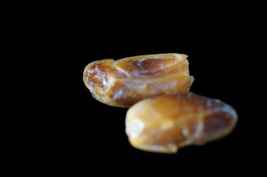 Sıcak renkli bir avuç dolusu hurma doğal bir yüzeye nazikçe uzanır. Derin parıltılarını ve buruşuk dokularını ortaya çıkarır. Parlak ciltleri, doğal şeker bakımından zengin, karşı konulmaz bir tatlılığı çağrıştırıyor.. 