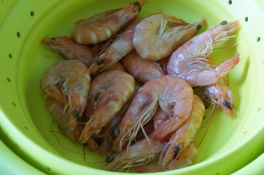 Taze ve lezzetli bir karides. Güzelce düzenlenmiş taze karides. Buzdan bir yatağa dikkatlice yerleştirilmiş. Canlı pembe tonu ve narin dokusu ışığı yakalayıp tazeliğini ve okyanus tadını vurguluyor..