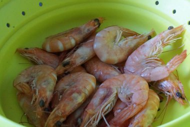 Taze ve lezzetli bir karides. Güzelce düzenlenmiş taze karides. Buzdan bir yatağa dikkatlice yerleştirilmiş. Canlı pembe tonu ve narin dokusu ışığı yakalayıp tazeliğini ve okyanus tadını vurguluyor..