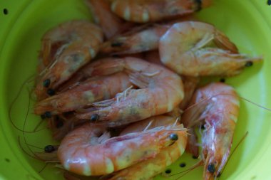 Okyanus Lezzeti: Taze ve Lezzetli Karides, buzdan bir yatağa dikkatlice yerleştirilmiş taze karides seçimi. Canlı pembe renkleri ve narin dokuları ışığı yakalayarak tazeliklerini ve okyanus lezzetlerini ön plana çıkarıyor..