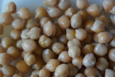 Kır dokusunu ve doğal sıcaklığını vurgulamak için ustalıkla hazırlanmış, altın sarısı kurutulmuş nohutlardan oluşan yakın plan. Bu mütevazı maddeye sessiz bir övgü, pek çok dünya mutfağının temel taşı..