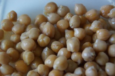 Kır dokusunu ve doğal sıcaklığını vurgulamak için ustalıkla hazırlanmış, altın sarısı kurutulmuş nohutlardan oluşan yakın plan. Bu mütevazı maddeye sessiz bir övgü, pek çok dünya mutfağının temel taşı..