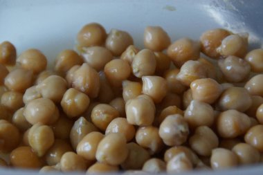 Kır dokusunu ve doğal sıcaklığını vurgulamak için ustalıkla hazırlanmış, altın sarısı kurutulmuş nohutlardan oluşan yakın plan. Bu mütevazı maddeye sessiz bir övgü, pek çok dünya mutfağının temel taşı..