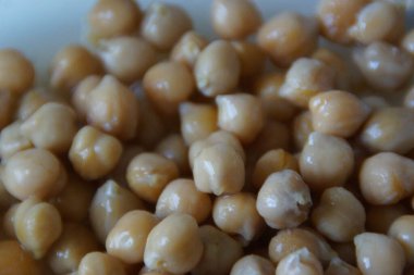 Kır dokusunu ve doğal sıcaklığını vurgulamak için ustalıkla hazırlanmış, altın sarısı kurutulmuş nohutlardan oluşan yakın plan. Bu mütevazı maddeye sessiz bir övgü, pek çok dünya mutfağının temel taşı..