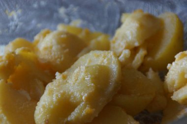 Hafif sirke soslu dilimlenmiş patates salatası. Kırmızı soğan, taze maydanoz ve bir tutam zeytin yağıyla süslenmiş tabak, sadelik ve yaz tazeliğini yakalar..