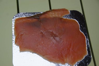 Yumuşak dalgalanmalarla doğal zarafetlerini arttıran yumuşak bir tabağa tütsülenmiş somon dilimleri. Somonların turuncu-pembe tonu ve ipeksi şeffaflığı hem ince hem de zengin tadını ortaya çıkarır.. 