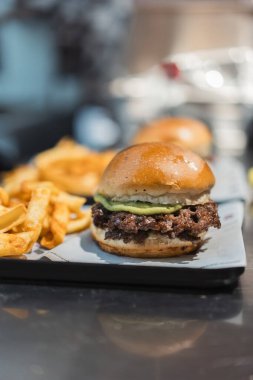 Kızarmış patatesle servis edilen lezzetli ezilmiş hamburger. Avokado soslu lezzetli hamburger..