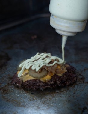 Çedarlı, turşulu, karamelli soğanlı ve ızgarada özel soslu hamburger köftesi.