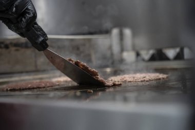 Şef, ızgarada hamburgerci köftesi pişiriyor...