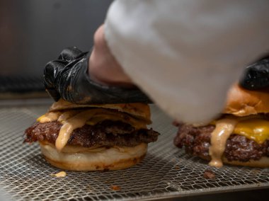 Şef, Restoran Mutfağında Özel Soslu Ezme Burgeri Hazırlıyor.