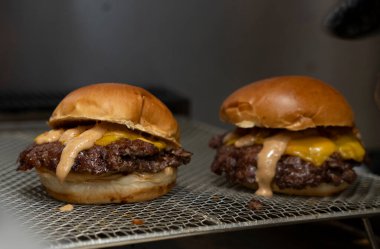 Özel soslu Smash Burger ve ızgarada erimiş peynirli sandviç.