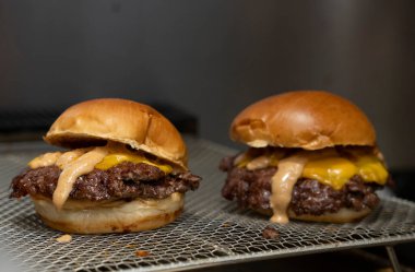 Özel soslu Smash Burger ve ızgarada erimiş peynirli sandviç.