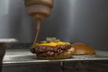 Erimiş çedar ve turşu soslu Smash Burger Patty 'nin yakın çekimi