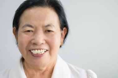 Asian elderly woman smiling happily looking forward