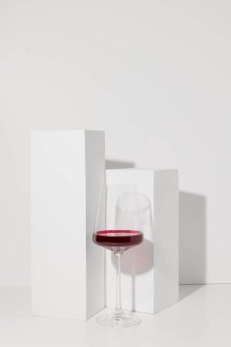 Kırmızı şarap beyaz arka planda cam ve gölgeli.