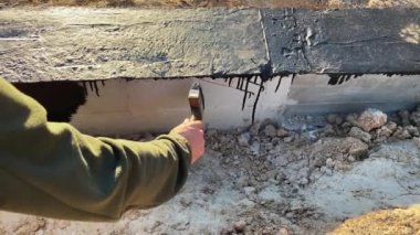 İnşaatçı daha fazla duvar döşemesi için beton temelin tepesine devasa bir astar uygular. 4K video ağır çekim. Temel su geçirmez inşaat çalışmaları