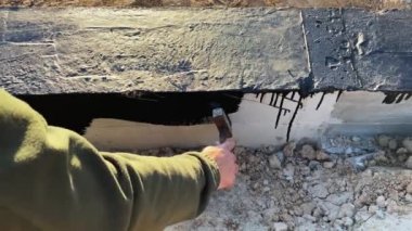 İnşaatçı daha fazla duvar döşemesi için beton temelin tepesine devasa bir astar uygular. 4K video ağır çekim. Temel su geçirmez inşaat çalışmaları