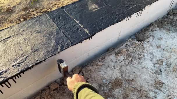 Pembangun Menerapkan Primer Bituminous Atas Fondasi Beton Untuk Peletakan Dinding — Stok Video