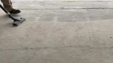 Construction works. The builder removes dust and small debris from the surface of the cement-sand screed using a vacuum cleaner for further finishing work. 4k video footage