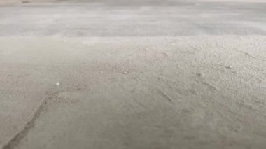 Construction works. The builder removes dust and small debris from the surface of the cement-sand screed using a vacuum cleaner for further finishing work. 4k video footage