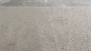 Construction works. The builder removes dust and small debris from the surface of the cement-sand screed using a vacuum cleaner for further finishing work. 4k video footage
