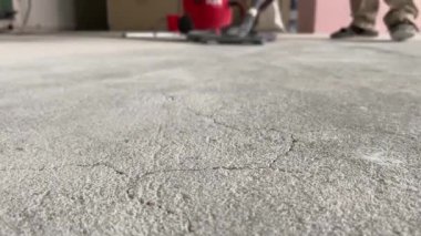 Construction works. The builder removes dust and small debris from the surface of the cement-sand screed using a vacuum cleaner for further finishing work. 4k video footage
